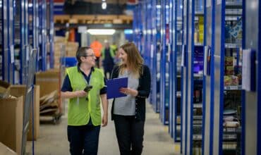 Two employees walking through a warehouse