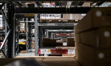 A tunnel view of warehouse shelves stocked with pallets and packages